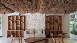 Uma sala de estar moderna com parede de pedra, prateleiras de madeira, um sofá e uma mesa de centro.