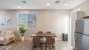 A modern kitchen with a dining table, chairs, a refrigerator, a trash bin, and a potted plant. - Glendale 1BR/1BA 3 Beds Pool, Gym & Parking (Glendale)