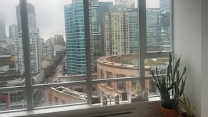 Uitzicht vanuit een hotelkamer op een stadsbeeld met hoogbouw, waaronder een Hilton hotel.