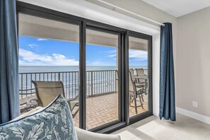 A balcony with a view of the ocean, furnished with chairs and a table. - Sunrise View • Waterfront • Heated Pool • Full Kitchen (Gulf Shores)