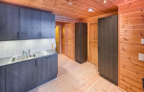 A modern kitchen with dark cabinets, a stainless steel sink, and a hexagonal tile backsplash.