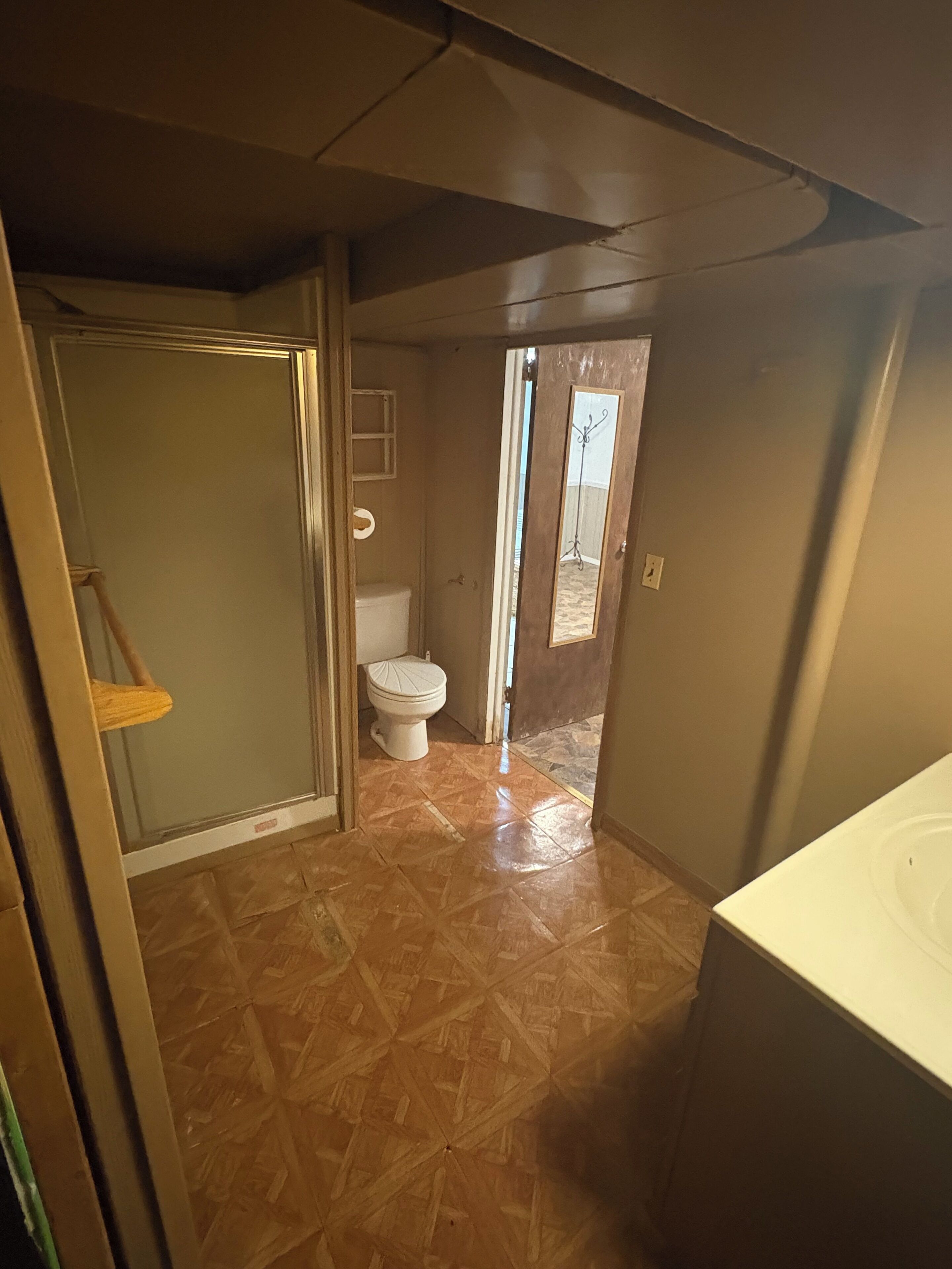 Une salle de bain comprenant des toilettes, un espace douche et un lavabo.