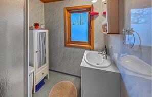 Un bagno compatto con finestra, lavandino e specchio.