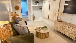 Ein modernes Wohnzimmer mit einem grünen Sofa, einem runden Couchtisch und einer sideboard mit Muster.