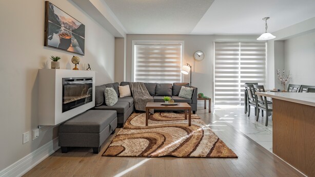 A modern living room with a sectional sofa, a coffee table, and a fireplace.