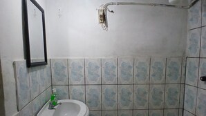 Un baño pequeño con lavamanos, espejo e inodoro.