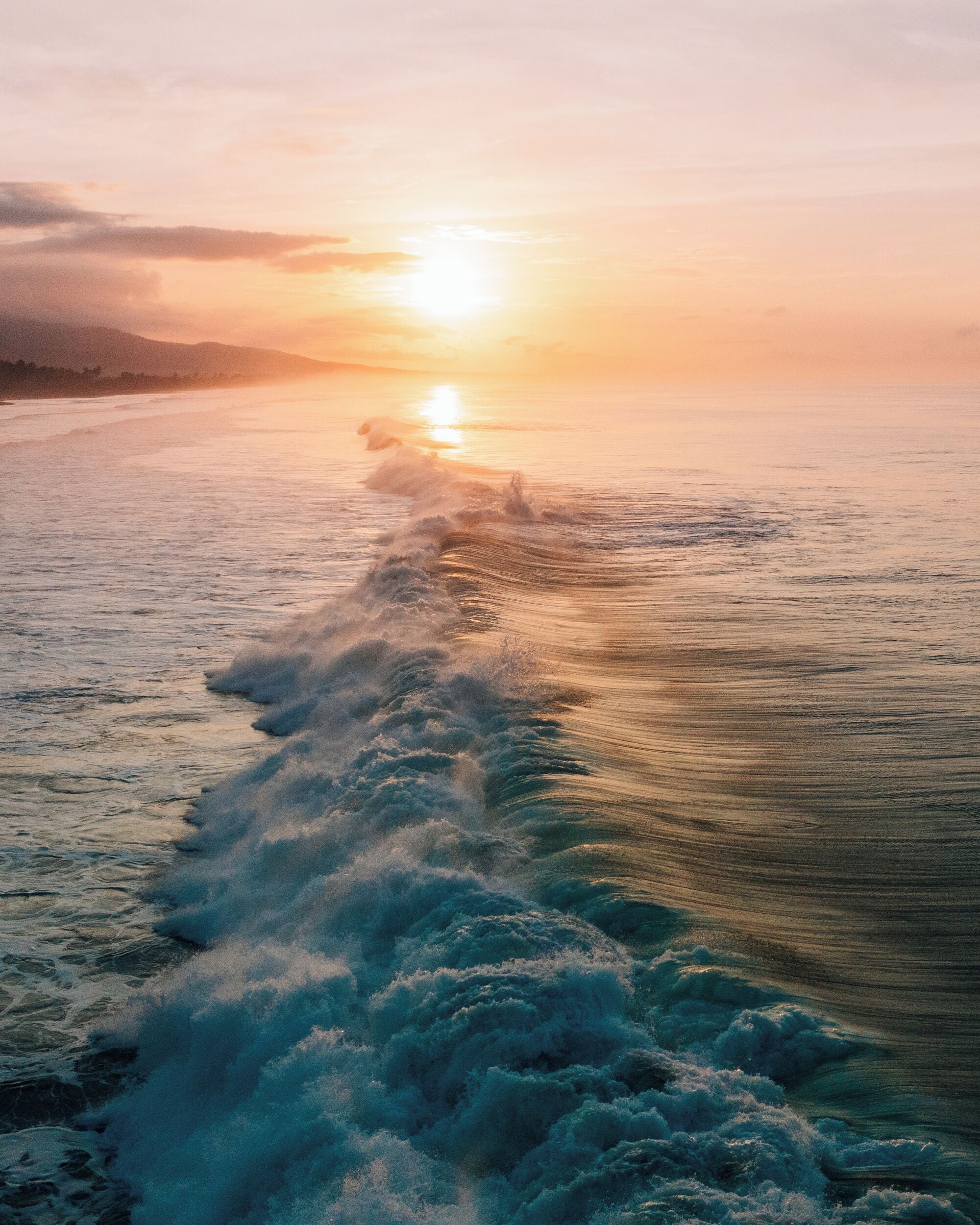 A sunset over a body of water with waves.