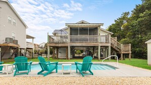 A two-story house with a balcony, a swimming pool, and outdoor seating. - Five minute walk to the beach, and a pool in Oak Island! Time for family fun! (Oak Island)