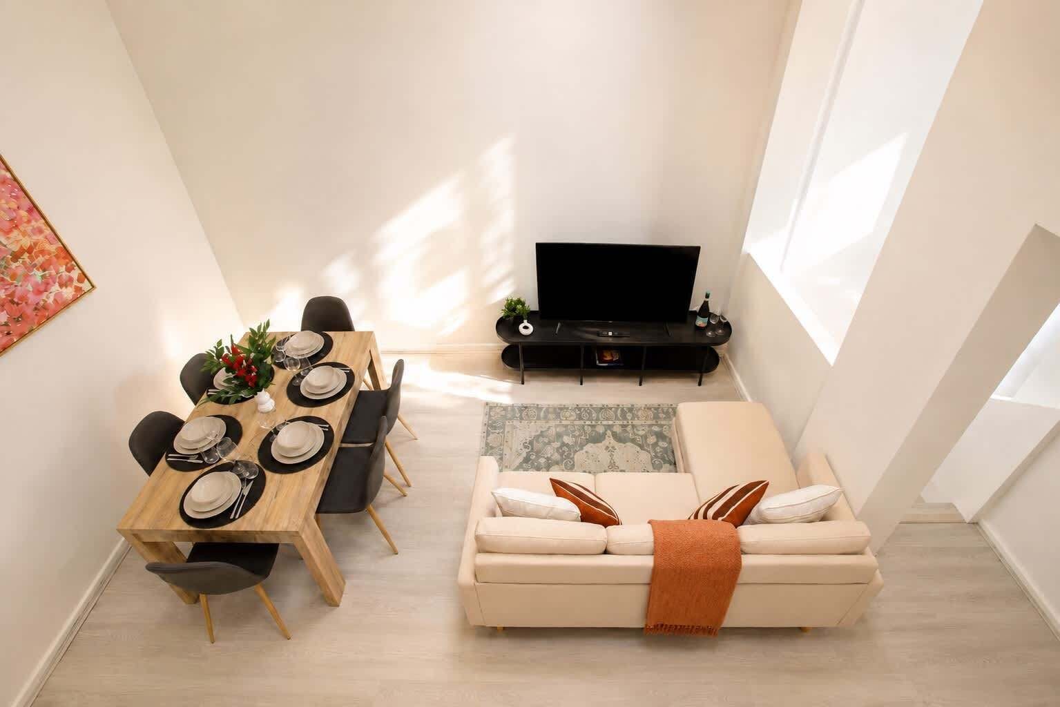 Un salon moderne comprenant un coin repas, un canapé et un téléviseur à écran plat.