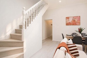 A staircase leading to a dining area with a table set for two. - The Jones | Modern 3BR Glebe Terrace with BBQ -  Near CBD - Walk to Markets & Shops (Glebe)