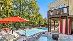 Ein Garten mit Swimmingpool, Whirlpool und einer Sitzgelegenheit im Freien.