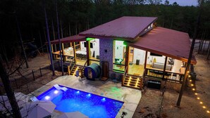 A house with a swimming pool, outdoor seating, and a covered patio area.