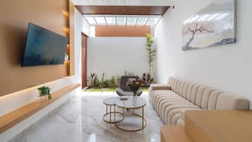 Villa ejecutiva | Área de sala de estar | Smart TV de 45 pulgadas con canales vía satélite