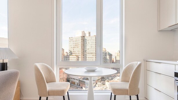 A modern kitchen with white cabinets, a round dining table, and two chairs. - Blueground | Downtown Brooklyn, rooftop, nr Brooklyn Bridge (New York)