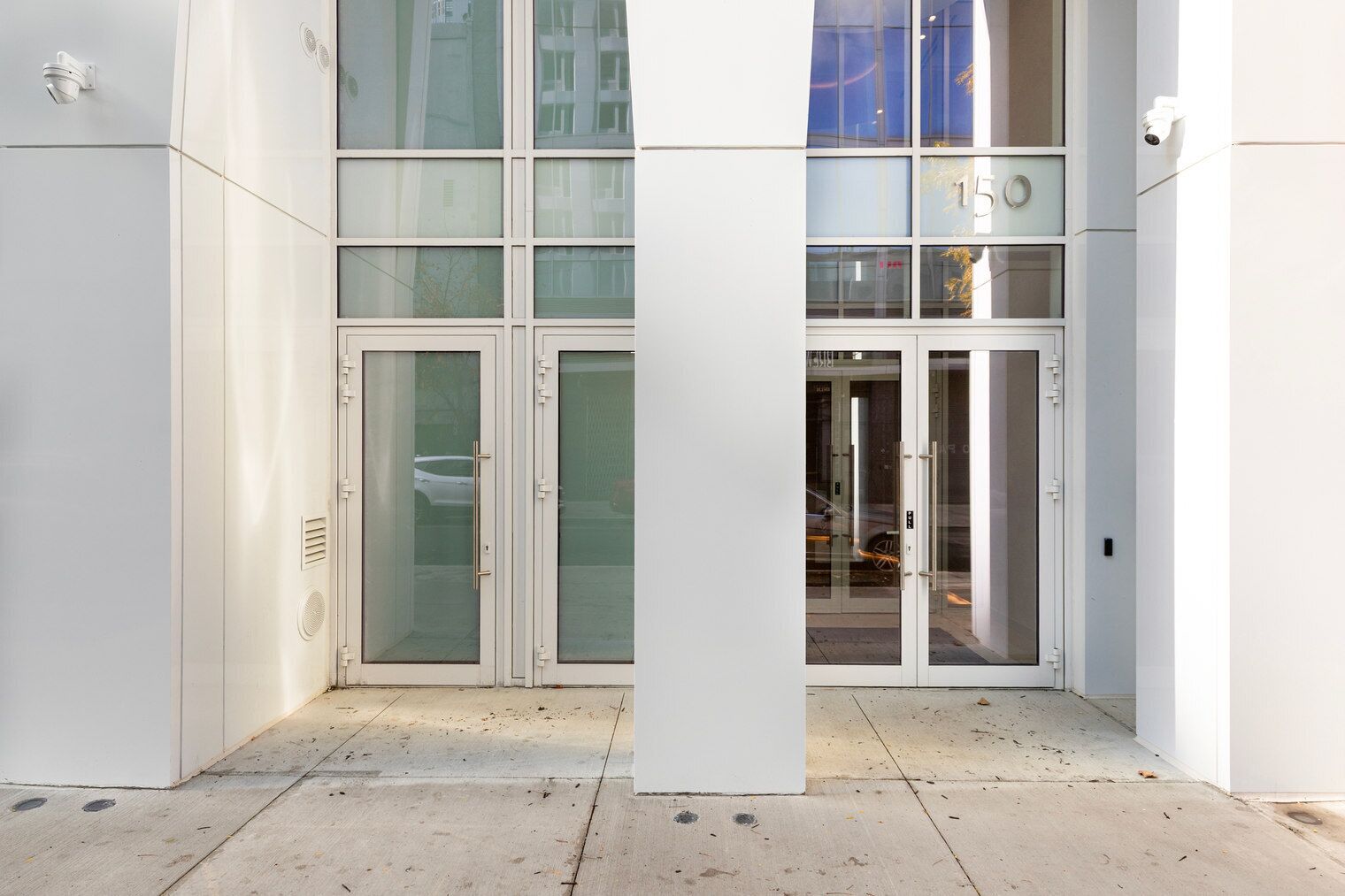 A modern building entrance with glass doors and a visible number '15' on the wall.