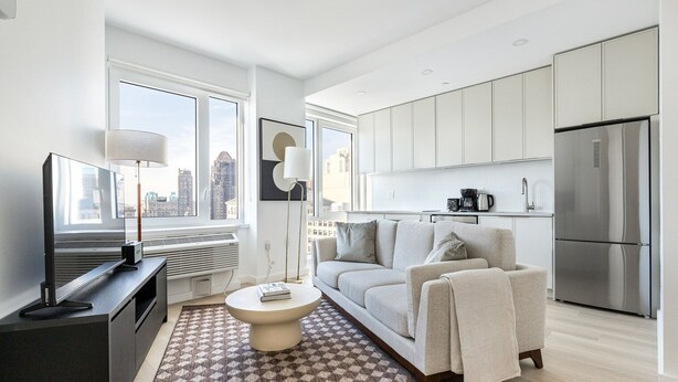 A modern apartment with a living room, kitchen, and a large window. - Blueground | Downtown Brooklyn, rooftop, nr Brooklyn Bridge (New York)