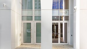 A modern building entrance with glass doors and a visible number '15' on the wall. - Blueground | Downtown Brooklyn, rooftop, nr Brooklyn Bridge (New York)