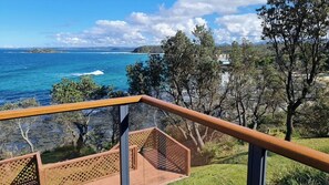 A balcony with a view of the ocean and a rocky coastline. - Bellevue overlooking the ocean (Manyana)