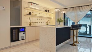 Uma cozinha moderna com frigorífico embutido, resfriador de vinhos e máquina de café.