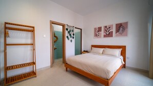 A bedroom with a wooden bed, a wooden wardrobe, and a door leading to another room. - Danka Luxury Villa (Batam)