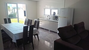 Una cocina compacta con comedor, un refrigerador y ventana con vista a un jardín.