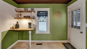 Una cucina con un piano di lavoro in legno, una macchina da caffè e una finestra con tende.