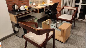 A compact office space with a desk, two chairs, a coffee maker, and a glass table. - Hotel Riverview Kishorganj (Kishoreganj Sadar)
