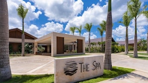 A spa complex with a central building, palm trees, and a clear sky.