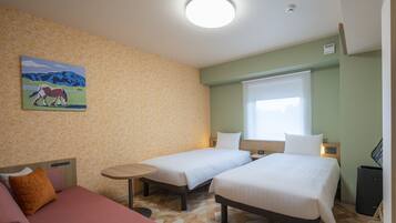 Habitación de hotel con dos camas, una mesita, un sofá, un cuadro en la pared y una ventana con persianas.