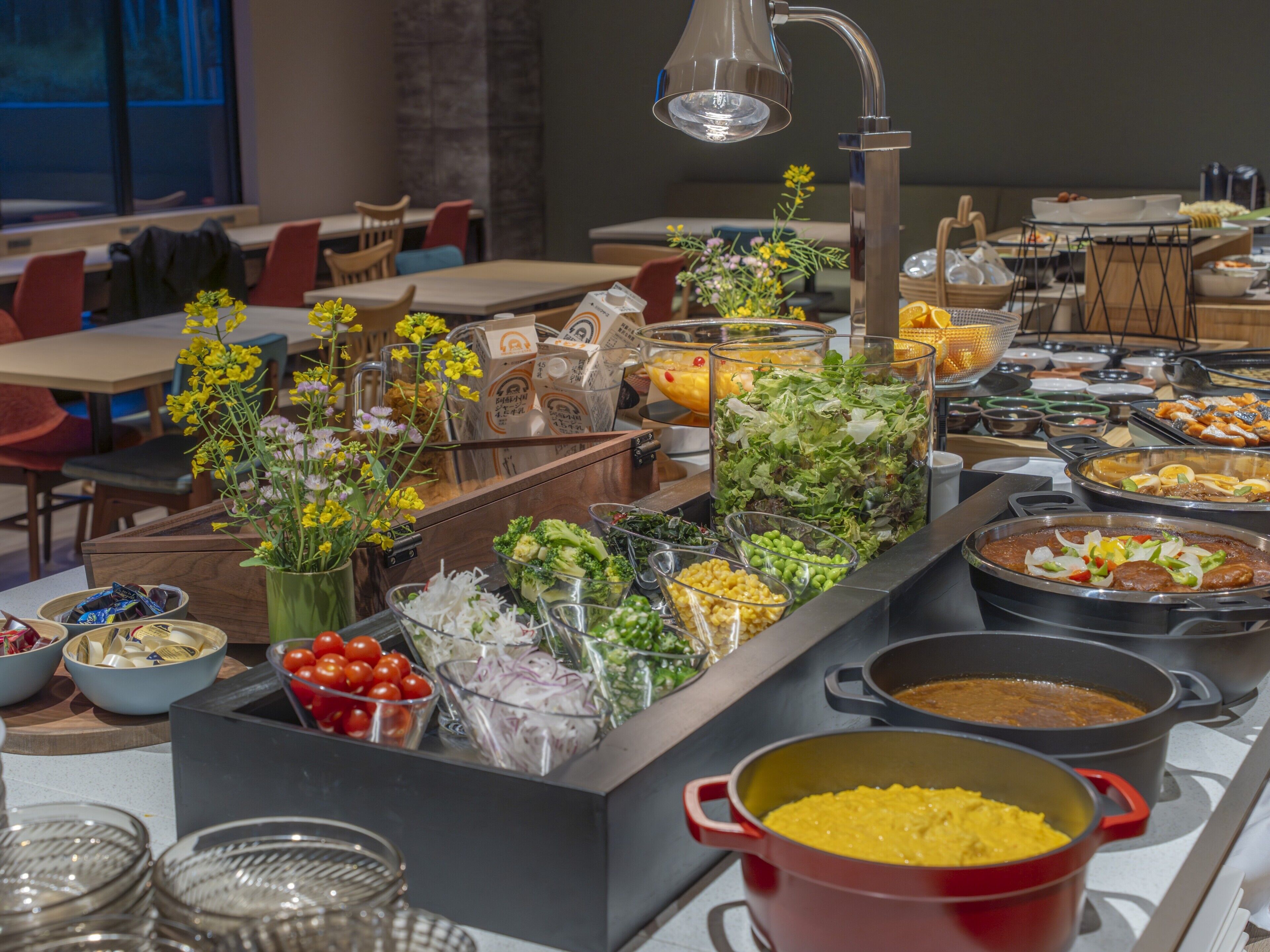 Ein Buffet mit verschiedenen Speisen, darunter Salate, Früchte und warme Gerichte.