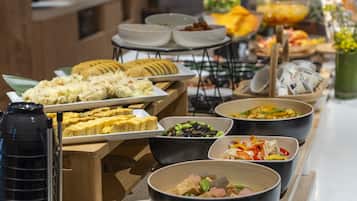 A buffet with various dishes and a coffee pot.