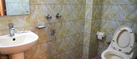 A bathroom with a sink, toilet, and a mirror.