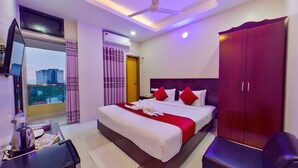 A hotel room with a bed, a wardrobe, a desk with a chair, a television, and a window with curtains. - Hotel Sea Cox (Cox's Bazar)