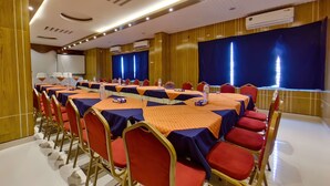 A conference room with multiple tables and chairs, air conditioning units, and a large screen. - Hotel Sea Cox (Cox's Bazar)