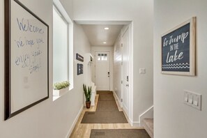 A hallway with a welcome sign, a motivational sign, and a potted plant.