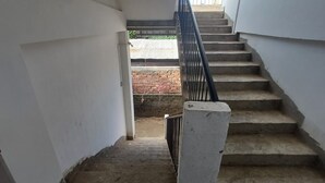 Un escalier avec une rampe métallique menant à un espace extérieur.