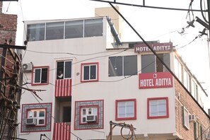 Un edificio a più piani con un cartello che riporta la scritta "HOTEL ADITYA".