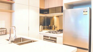 A modern kitchen with a stainless steel refrigerator, a built-in gas stove, and a double sink. - Gleaming Riverfront - Stay on Casino, Free Carpark (Brisbane City)
