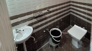 A bathroom with a white sink, a toilet, and a shower. - Gaurang home stay
Feel like a home (Dwarka)