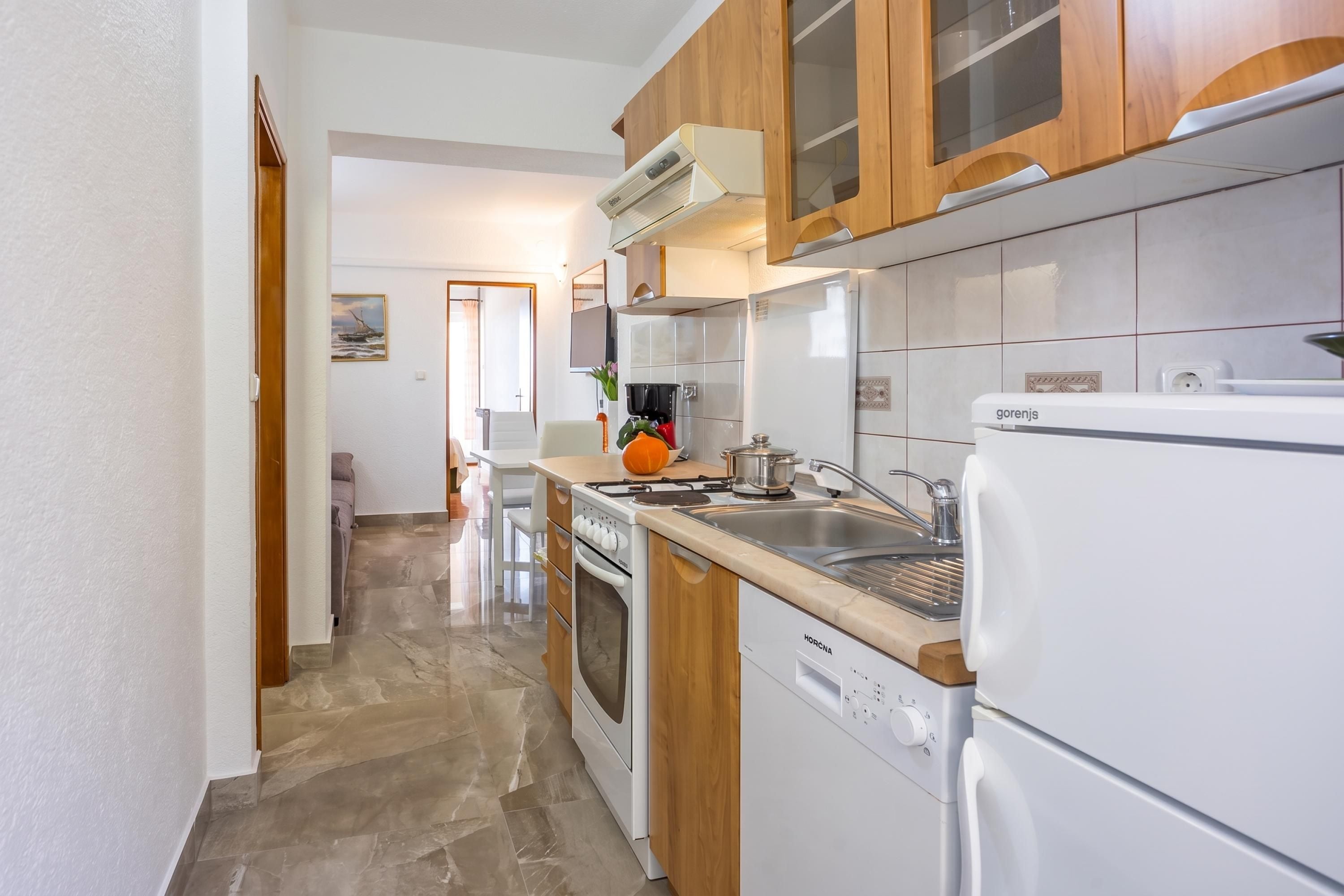 A kitchen with a stove, oven, sink, and a refrigerator.
