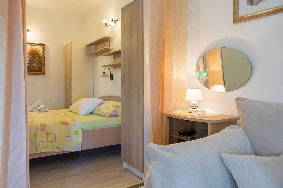 Une chambre à coucher avec un lit, une table de chevet, une lampe et un miroir au mur.