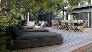 Una terrazza con un divano, sedie e un tavolo.