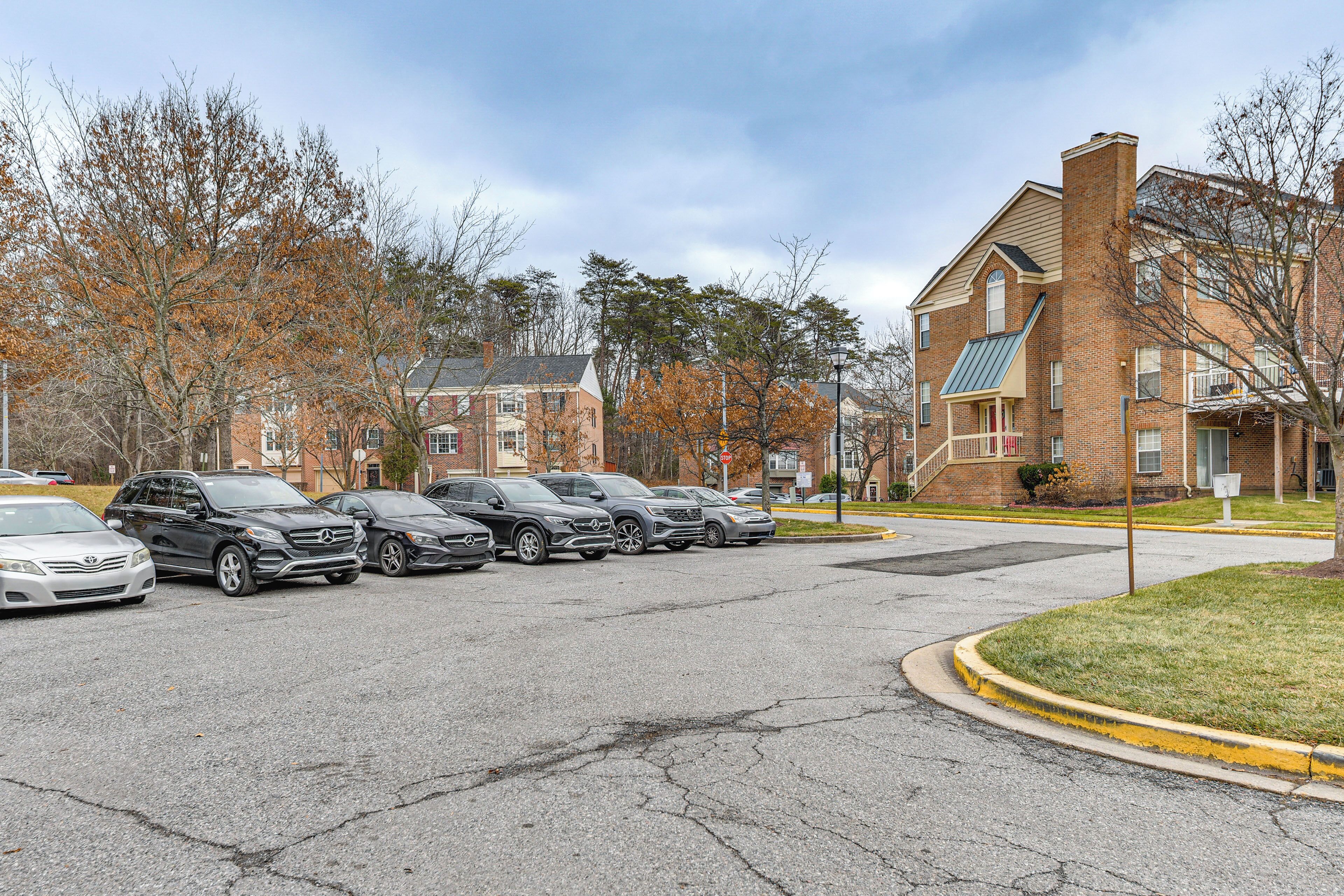 A parking lot with several cars parked in a row.
