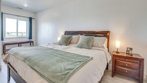 A bedroom with a large bed, a bedside table with a lamp, and a window with curtains. - 3 Mi to Kokopelli Trail: Outdoor Adventure Base (Loma)