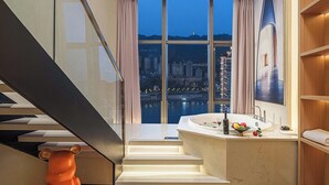 Un baño moderno con un amplio ventanal, una bañera y un lavamanos.