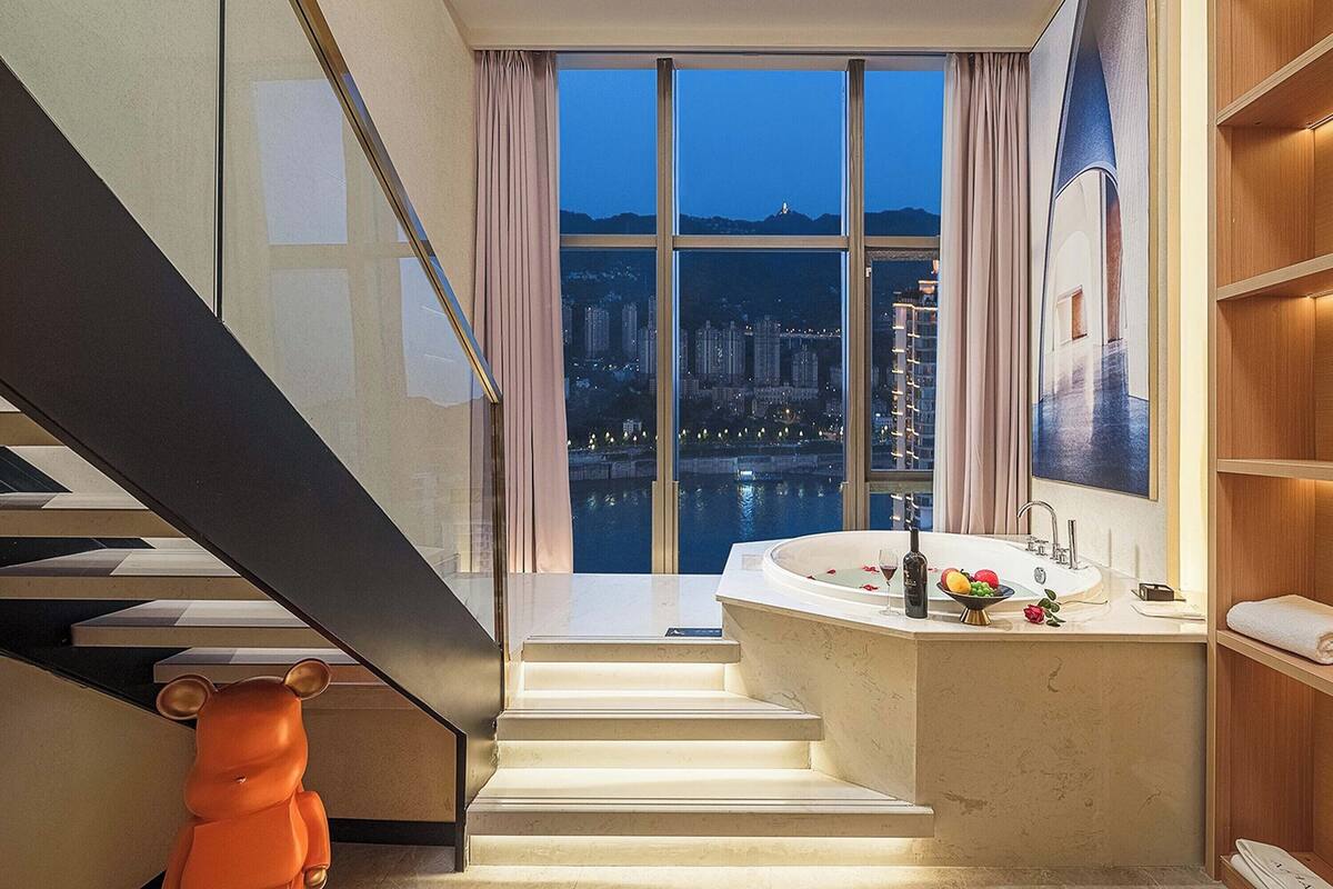 Een moderne badkamer met een groot raam, een badkuip en een wastafel.