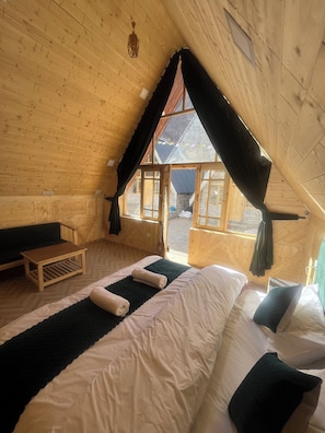 A cozy attic room with a bed, a small table, and a bench. - The Grand Lamkhaga By Mountain Bee (Chitkul)