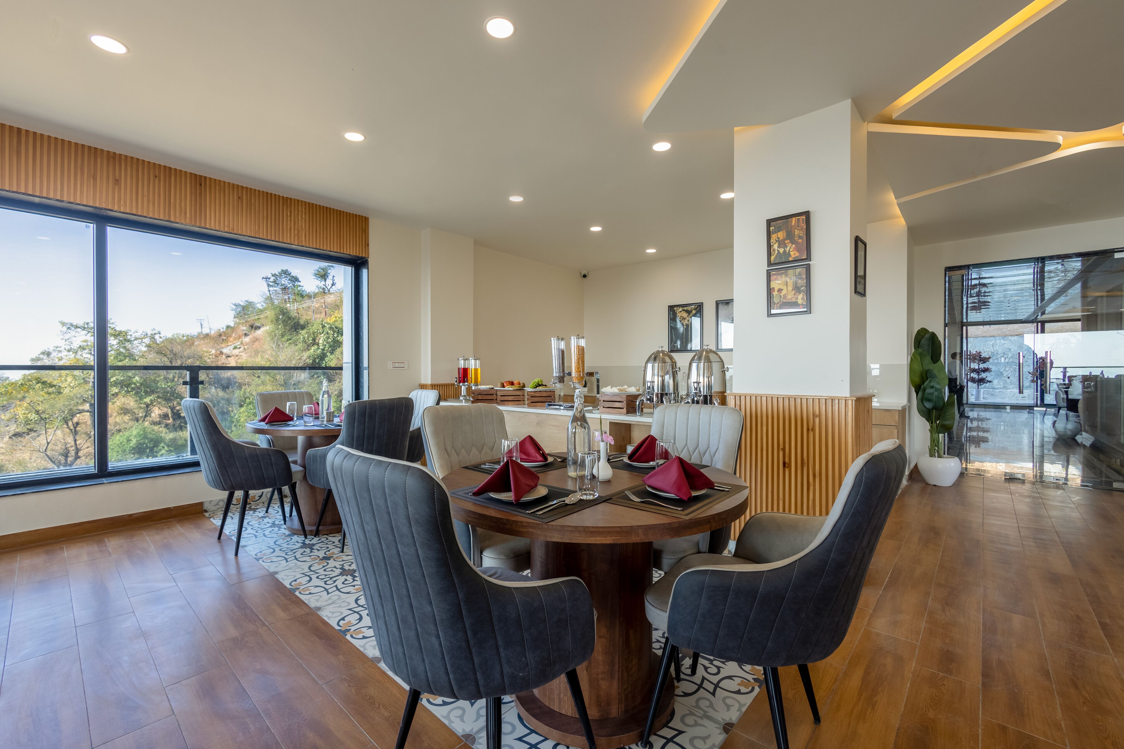 A modern dining area with a round table, multiple chairs, and a view of the outdoors.