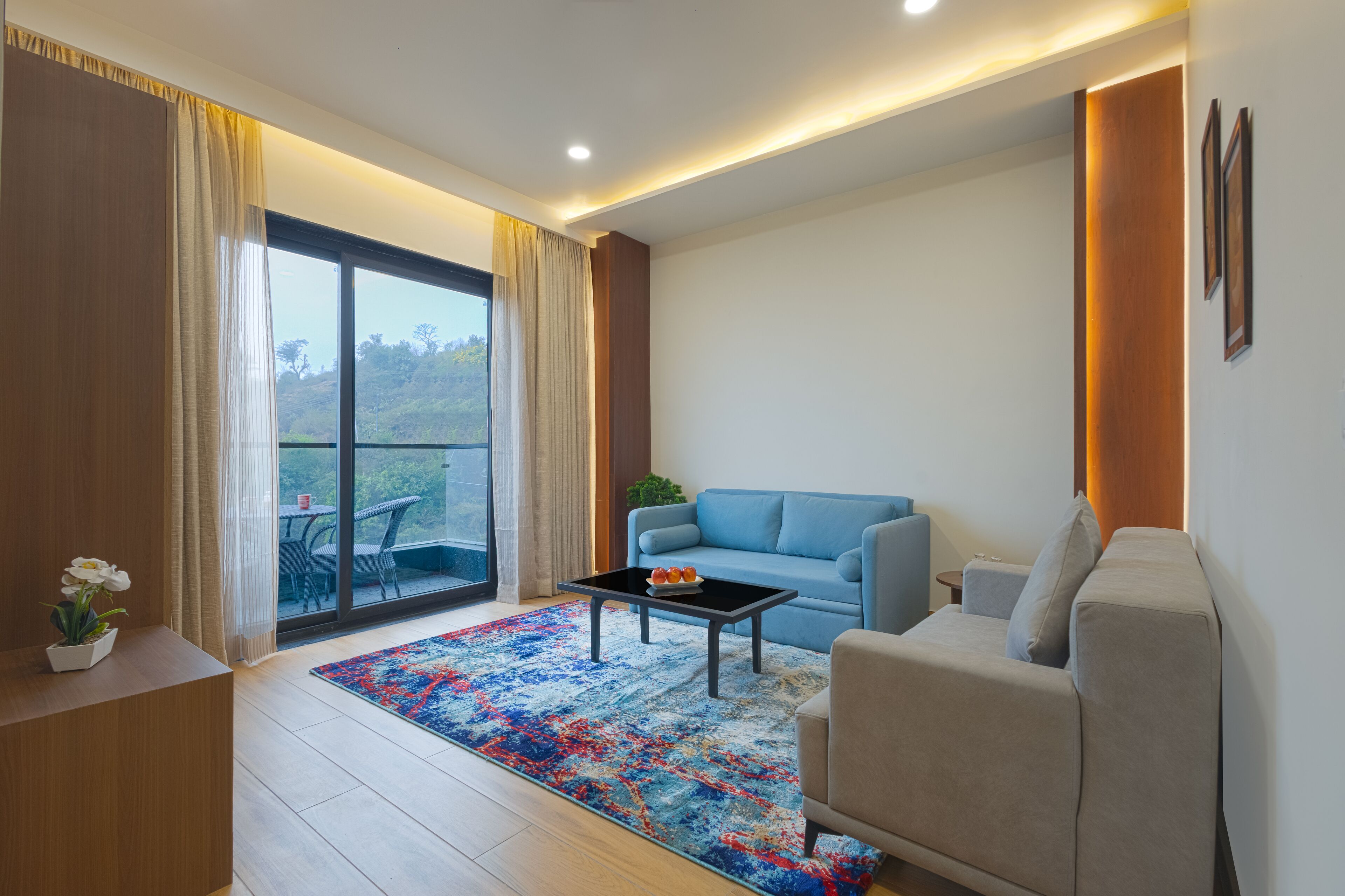 A modern living room with a sofa, coffee table, and a view of a balcony.