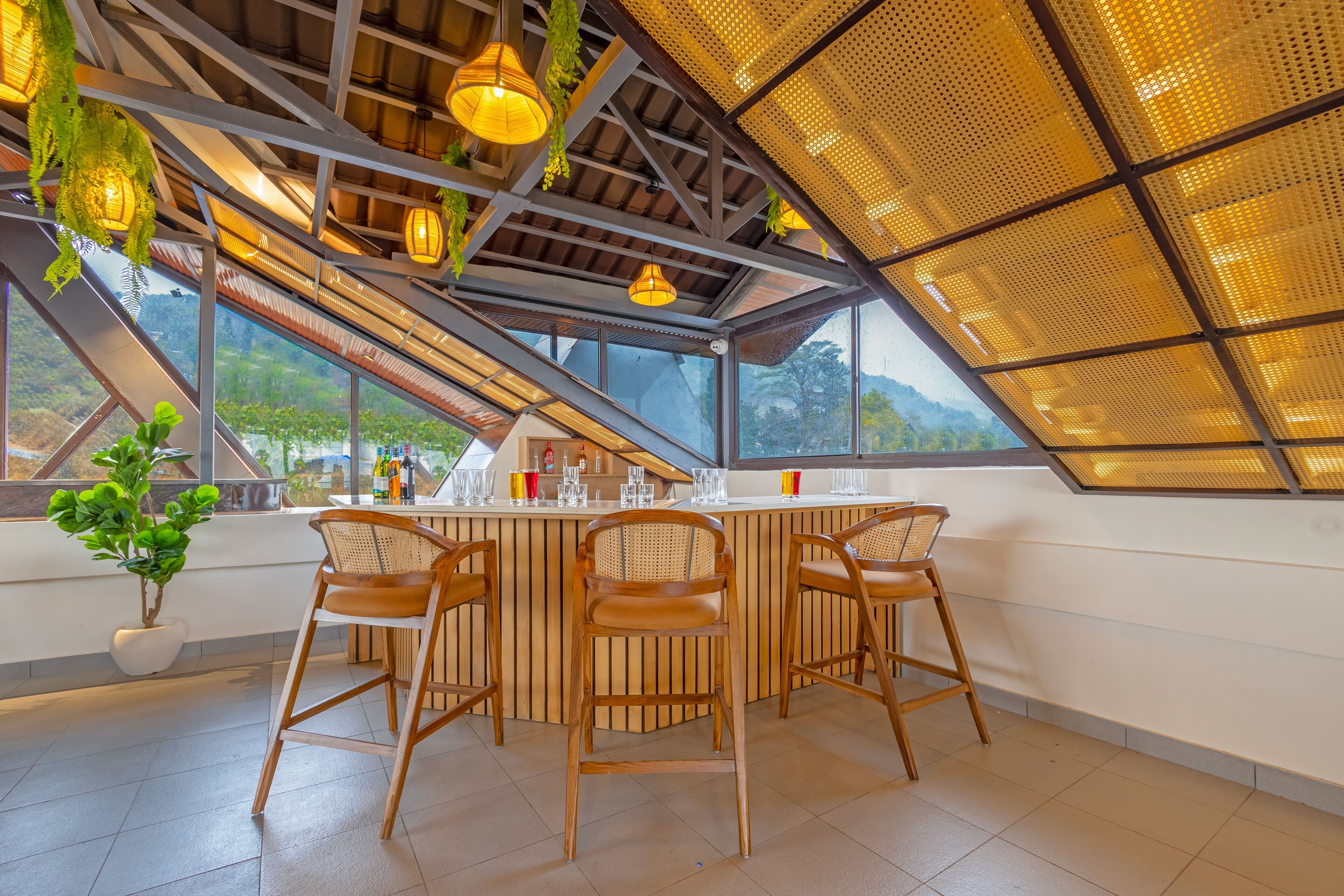 Un área de bar moderna con techo alto, ventanas amplias y vistas al exterior.
